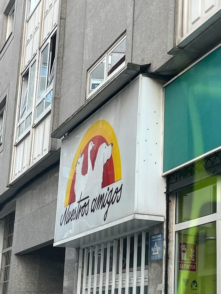 Rótulo de la clínica de cerca: el arco amarillo, coral y rojo con las siluetas de un gato, un ganso y un perro